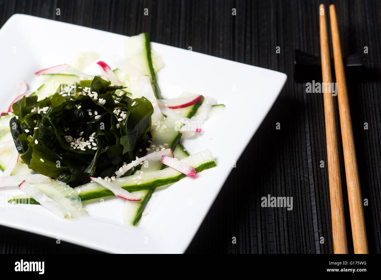 Healthy wakame and cucumber salad with radish and sesame seeds Stock Photo