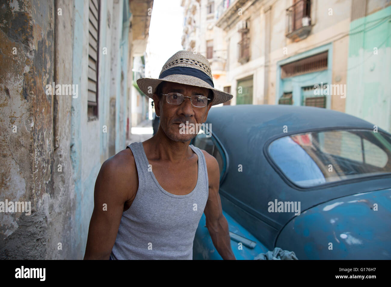 A Cuban man wearing a straw hat stands 