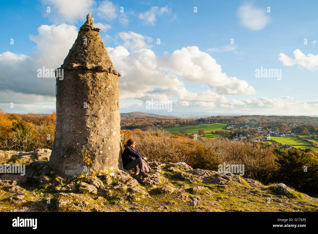 Walker sits below the ‘Pepperpot’ above Eaves Wood overlooking Silverdale Lancashire Stock Photo