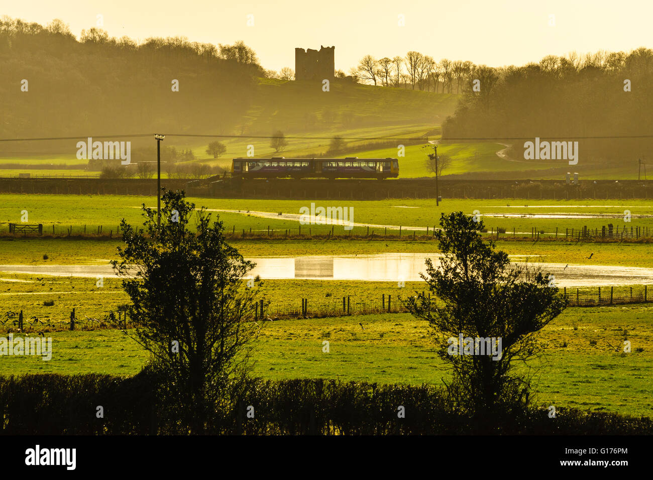Train passing in front of Arnside Tower in the Arnside-Silverdale Area of Outstanding Natural Beauty Cumbria England Stock Photo