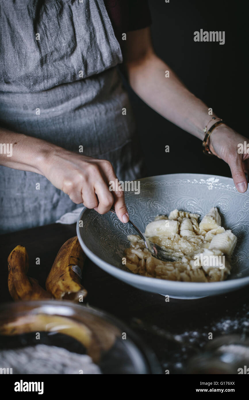 A woman is mashing bananas to be used in a banana bread donut recipe Stock Photo Alamy
