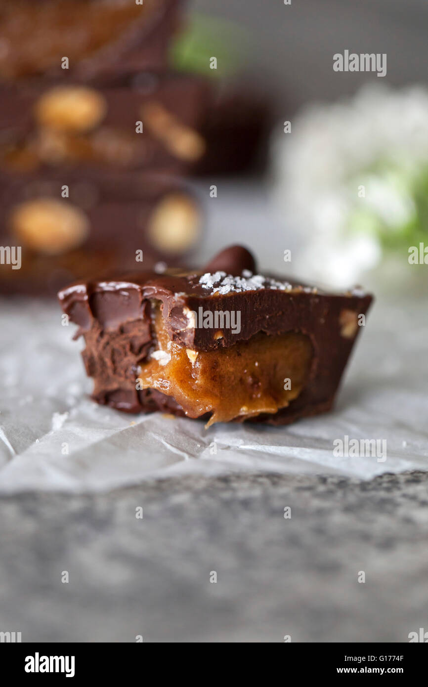 Close up of half eaten Chocolate cup filled with date caramel Stock Photo