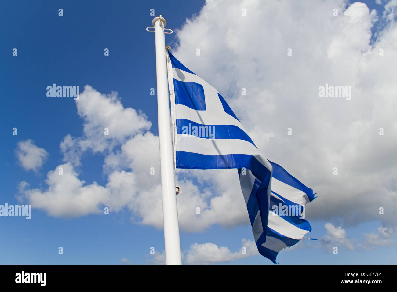 Flag of Greece in a blue skye with clouds Stock Photo