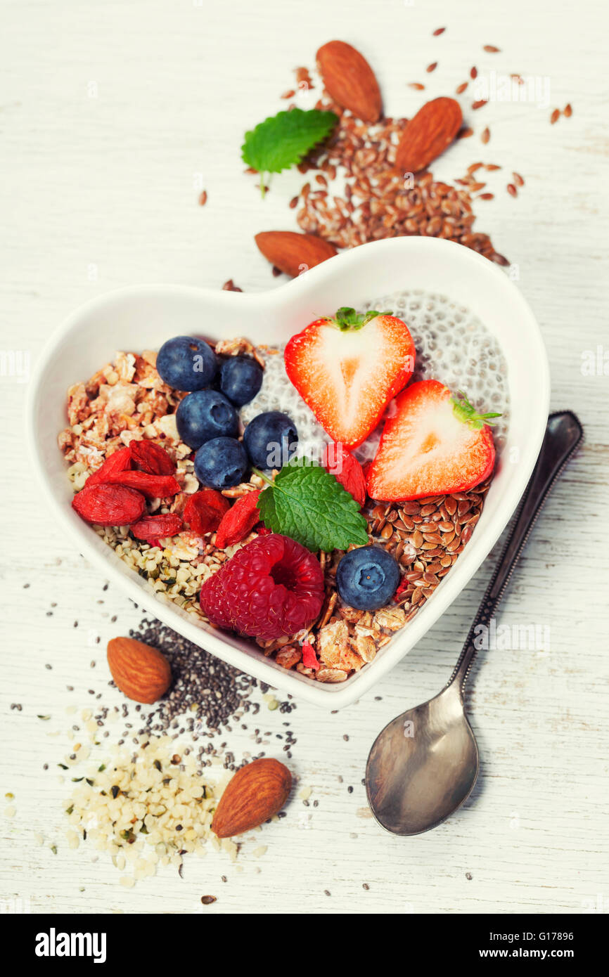 Healthy breakfast of muesli, berries with yogurt and seeds on white background -  Healthy food, Diet, Detox, Clean Eating or Veg Stock Photo