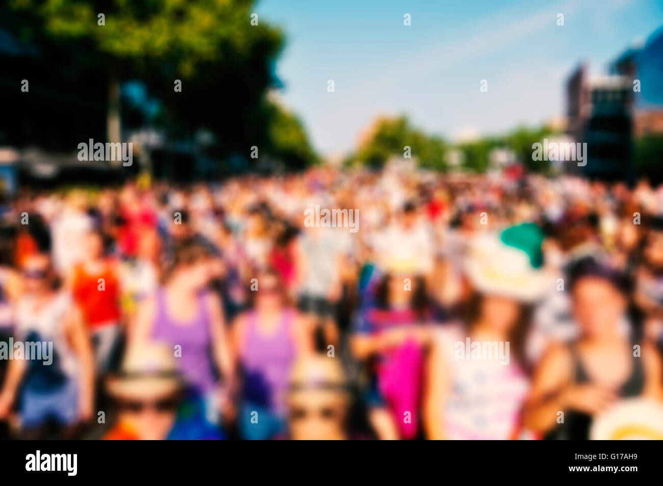 defocused background of a crowd of people partying or marching in a protest or in a parade outdoors Stock Photo
