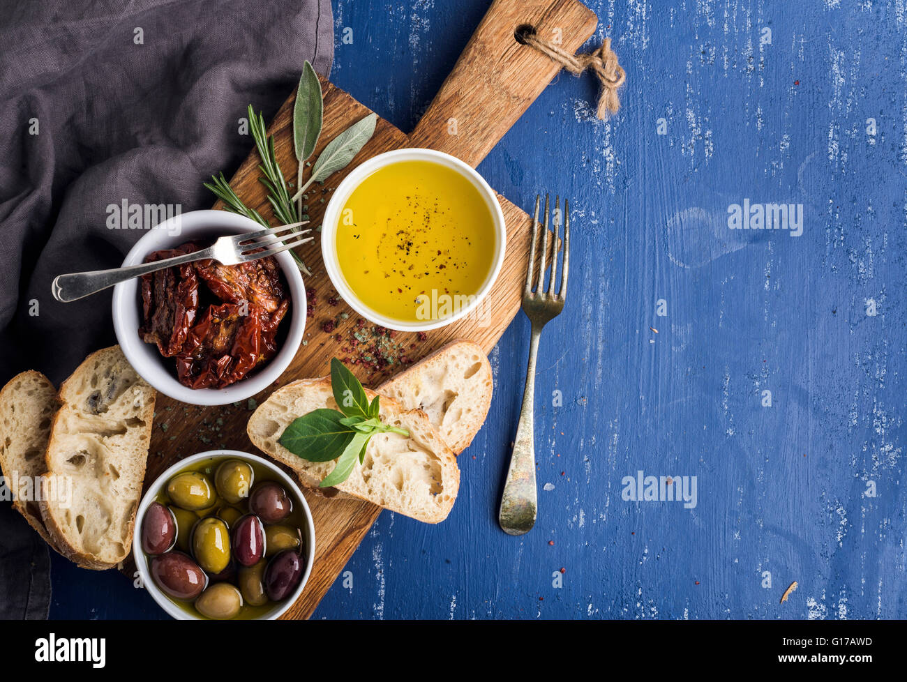 Mediterranean snacks set. Olives, oil, herbs and sliced ciabatta bread