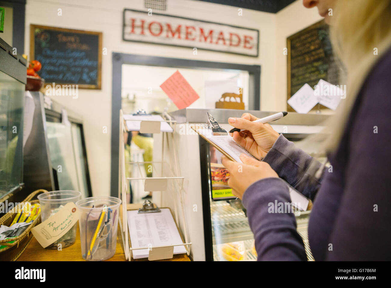 Customer filling order form in general store, Hague, USA Stock Photo