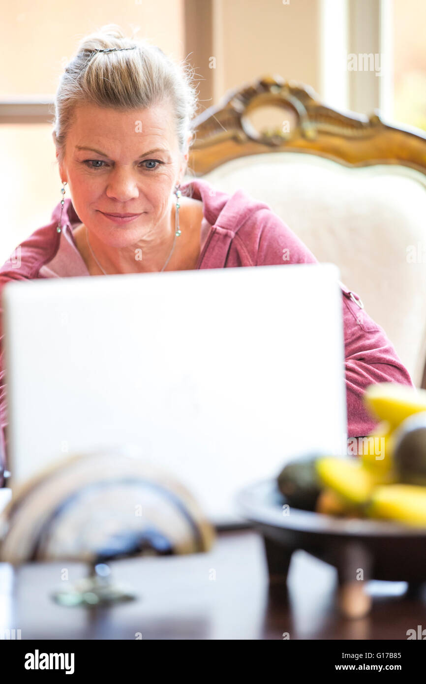 Woman using laptop at desk Stock Photo