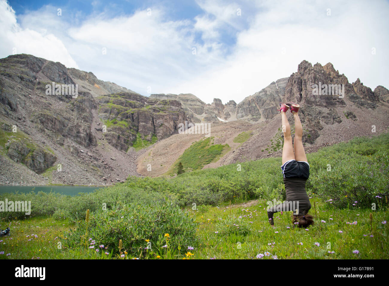 Woman practising yoga on meadow, Cathedral Lake, Aspen, Colorado Stock Photo