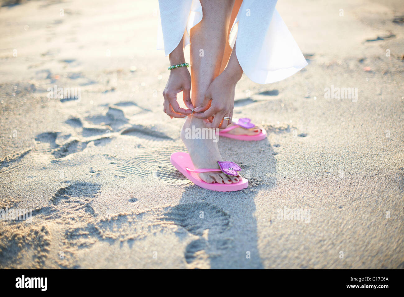 Cropped shot of woman fastening anklet on Santa Monica beach, Cresent