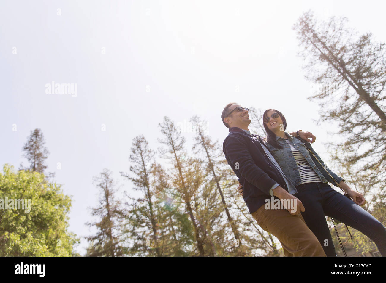 Low angle view of couple strolling wearing sunglasses Stock Photo