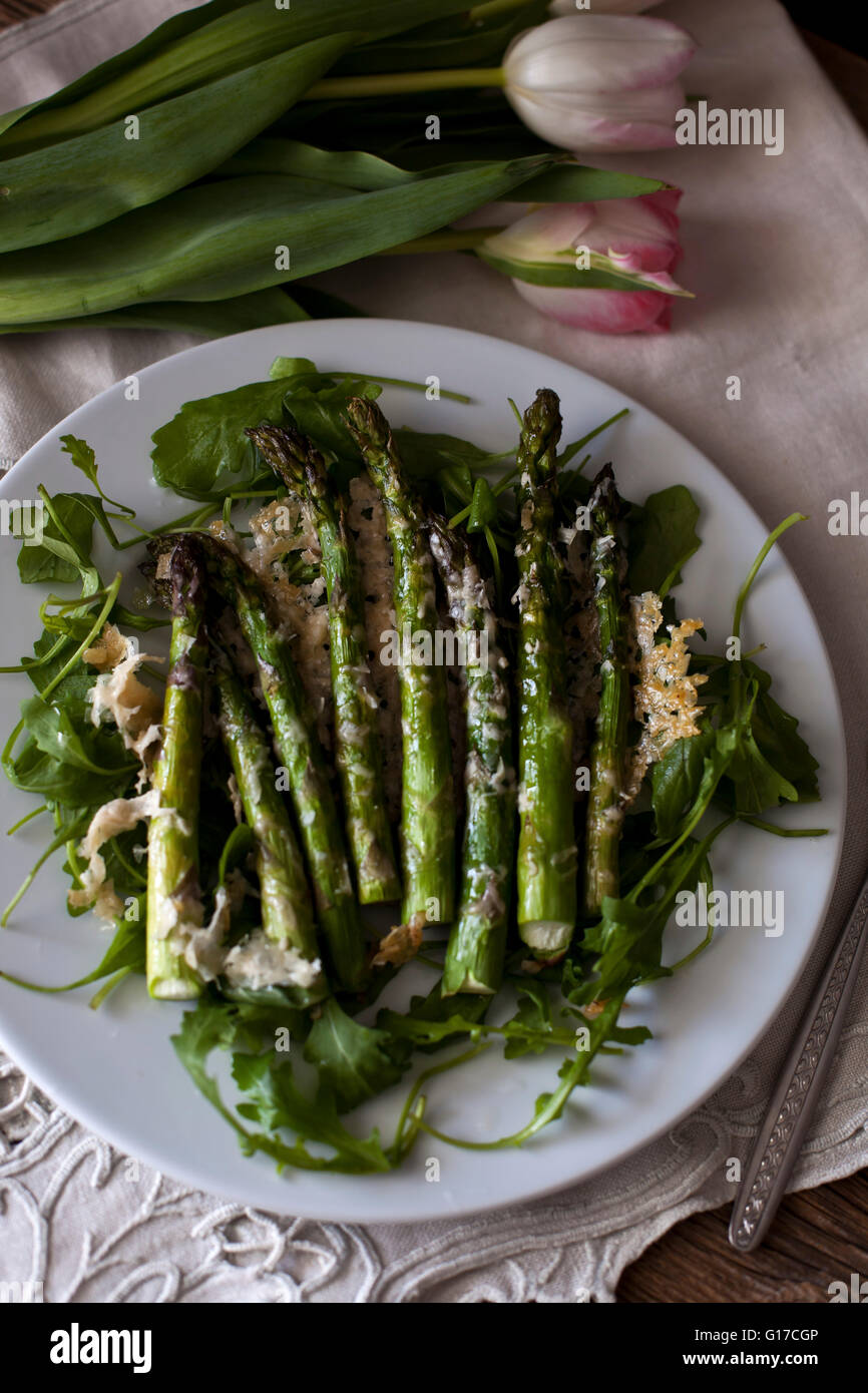 Roasted asparagus with Parmesan cheese on a bed of rucola salad Stock Photo