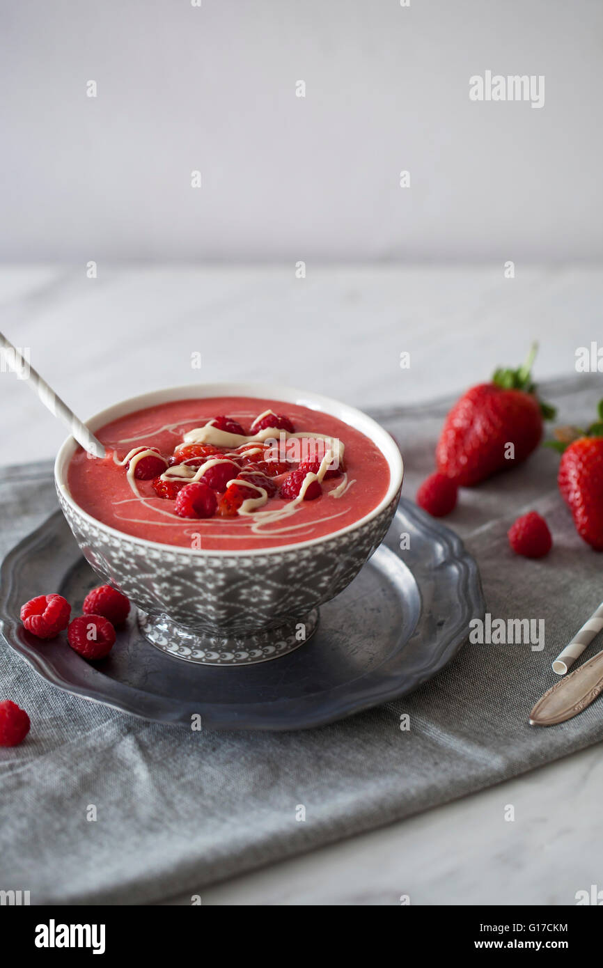 Refreshing Strawberry and raspberry smoothie topped with fresh berries and cashew butter in a bowl Stock Photo