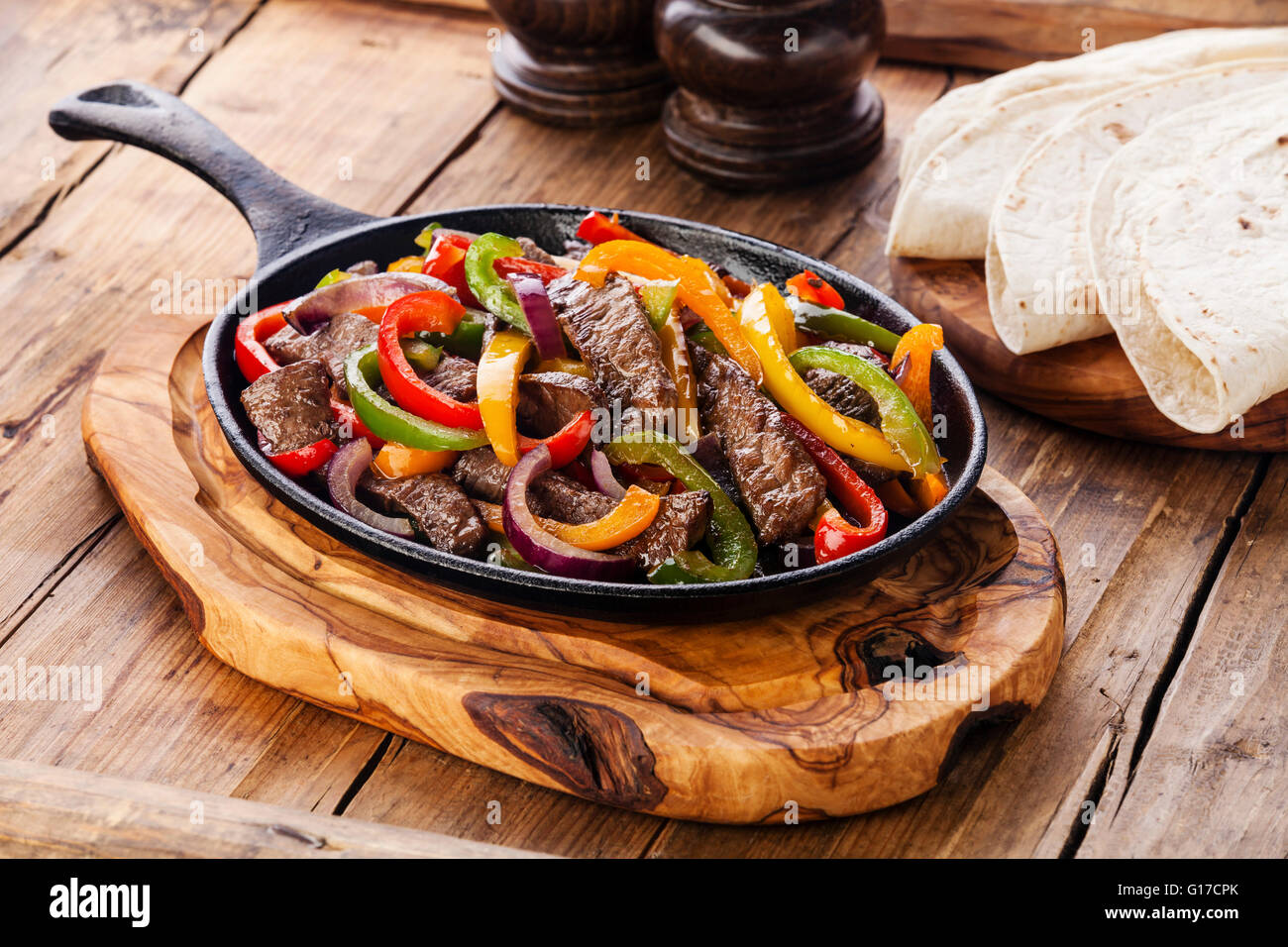 Beef Fajitas with colorful bell peppers in pan and tortilla bread Stock