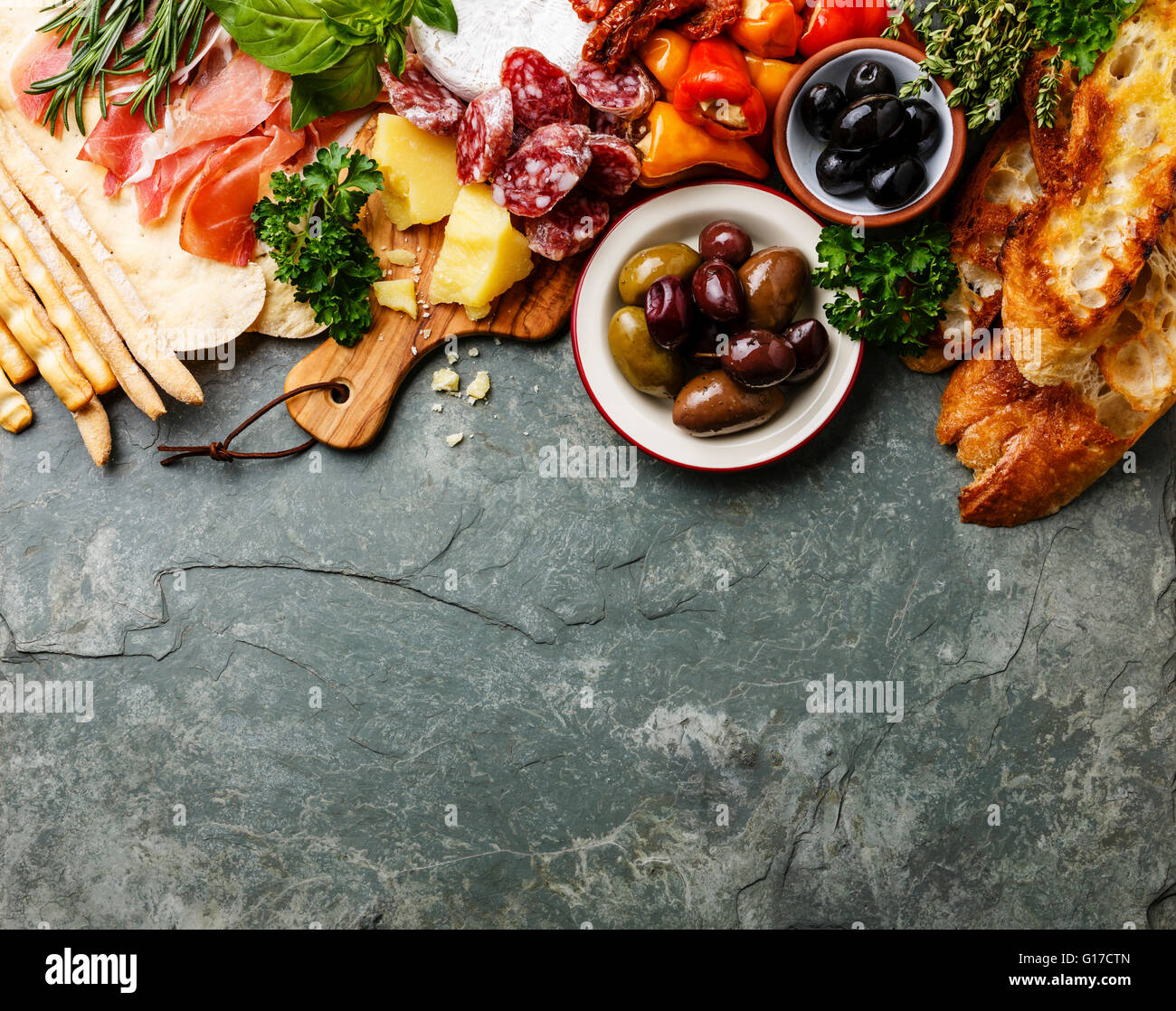 Italian food ingredients background with ham, salami, parmesan, olives, bread sticks Stock Photo