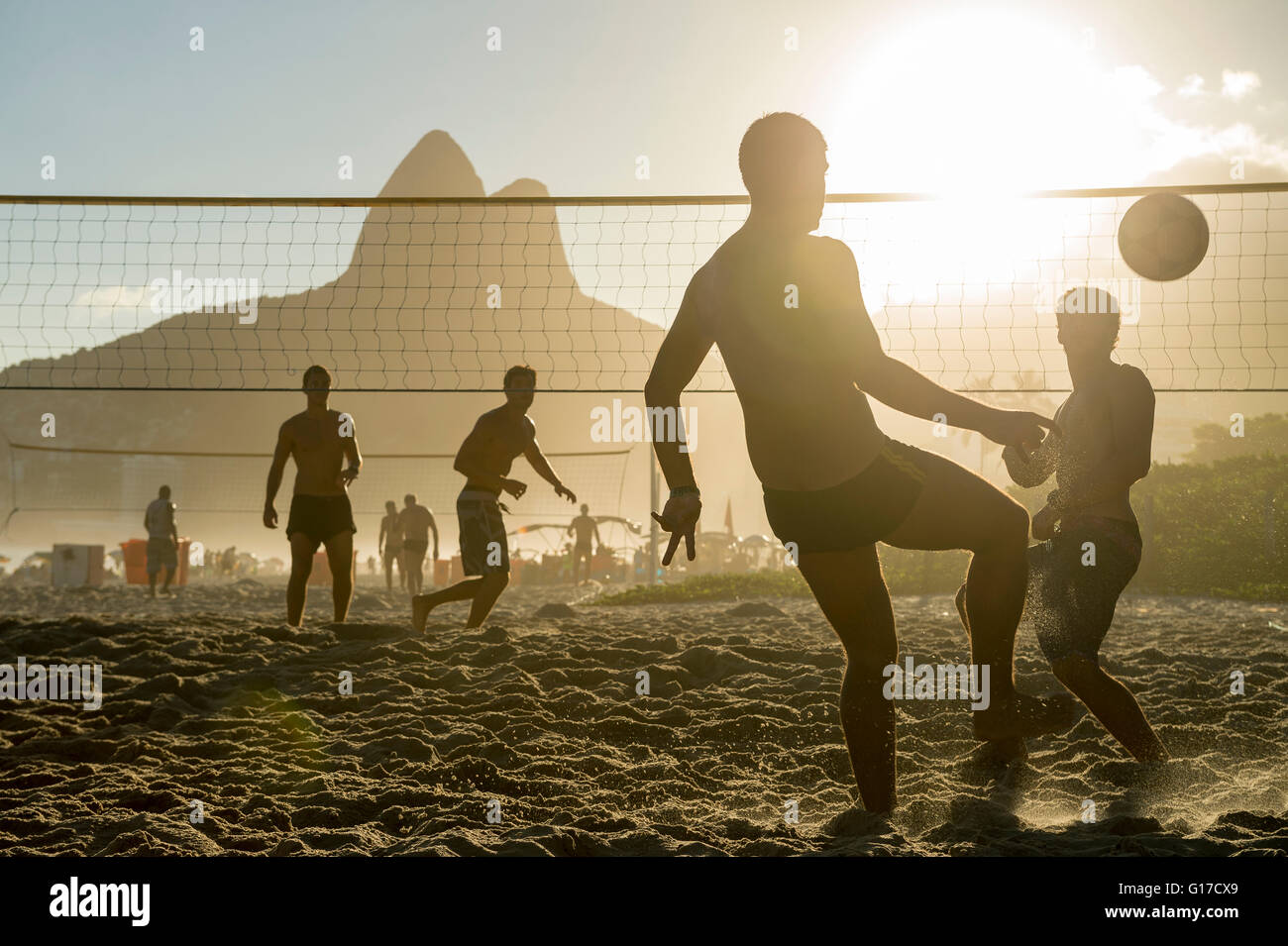 RIO DE JANEIRO - MARCH 27, 2016: Brazilians play beach futevôlei (footvolley), a sport combining football/soccer and volleyball. Stock Photo