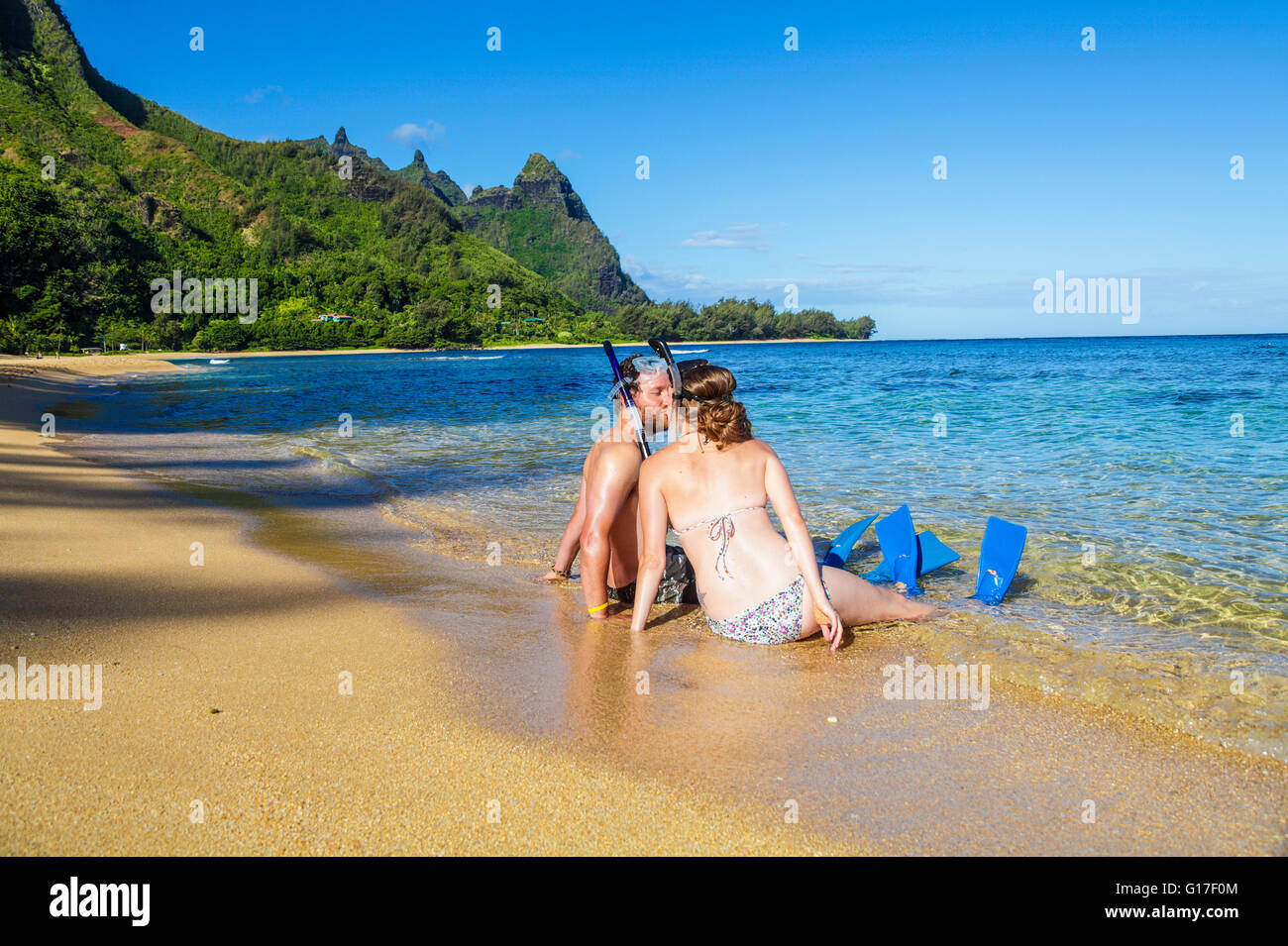 Honeymooners kiss at Tunnels Beach on Kauai Stock Photo