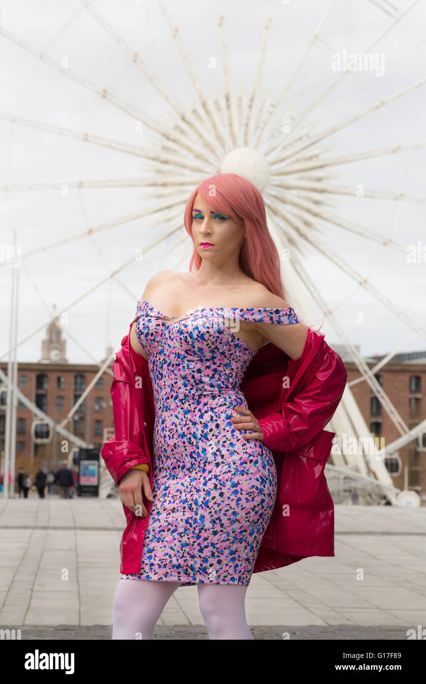 Pink hair model in front of big wheel Stock Photo