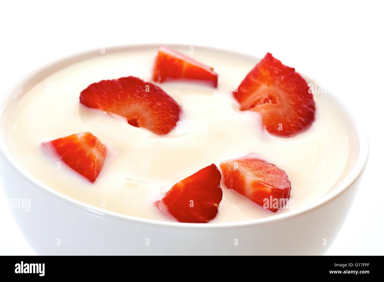 Yogurt with strawberries in bowl on white Stock Photo