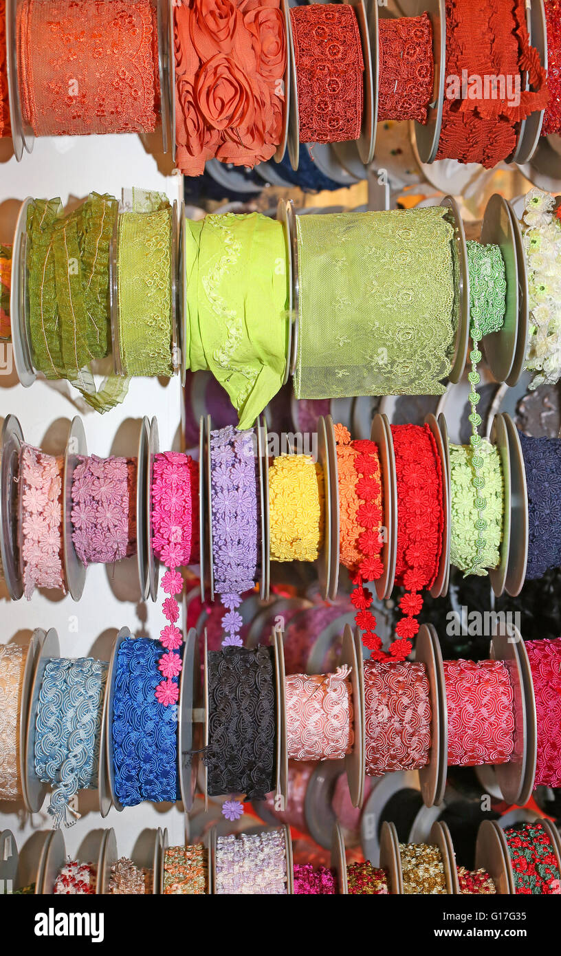 many colored ribbons and decorative rolls for sale per meter in the wholesaler's shop of articles for hobbyists Stock Photo