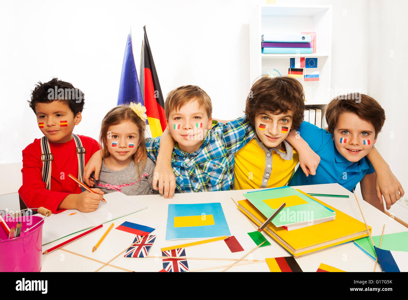 Kids learning languages sitting in line at a desk Stock Photo Alamy