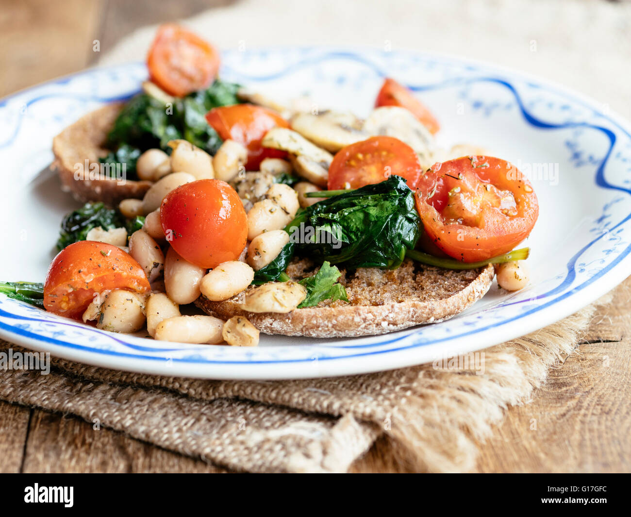 English muffins with Mushrooms, Beans, Spinach and Tomatoes Stock Photo