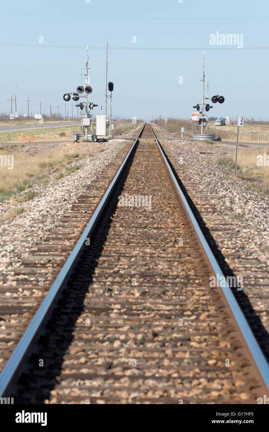 Railroad tracks and road crossing in West Texas. Stock Photo