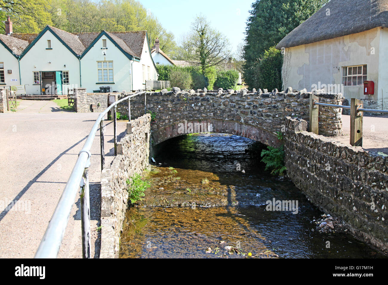A quaint picture postcard Devon Village, with thatched cottages and a small stream running through. Stock Photo