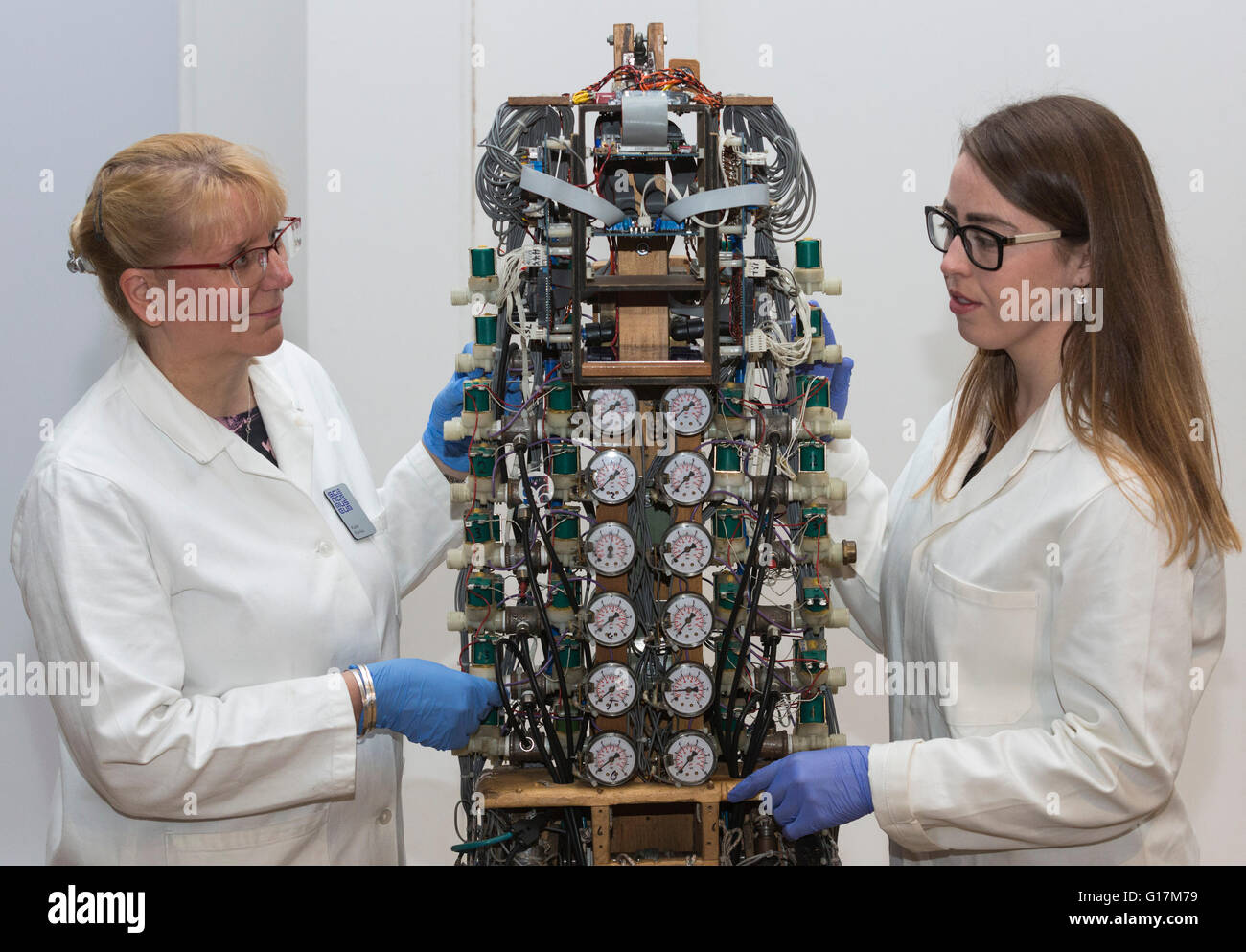 London, UK. 10 May 2016. Conservators Kate Perks and Vanessa Applebaum examine the Bipedal Walker robot, built by David Buckley and the Shadow Robot Project Group, 1987-97. The London Science Museum announces Rise of the Robots, the remarkable 500-year history of robots, in a new exhibition starting February 2017. Over 100 robots will feature in the exhibition which makes it the most significant collection of humanoid robots ever displayed in the world. Stock Photo