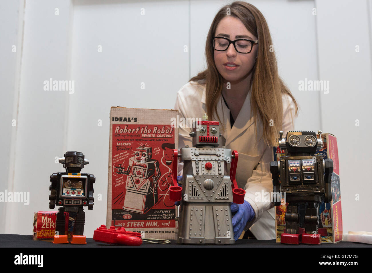 London, UK. 10 May 2016. Pictured: conservator Vanessa Applebaum handles toy robots L-R: Mr Zero, Robert the Robot and the Super Astronaut Robot. The London Science Museum announces Rise of the Robots, the remarkable 500-year history of robots, in a new exhibition starting February 2017. Over 100 robots will feature in the exhibition which makes it the most significant collection of humanoid robots ever displayed in the world. Stock Photo