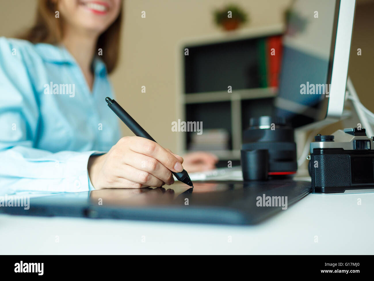 Young woman artist drawing something on graphic tablet at the home office Stock Photo