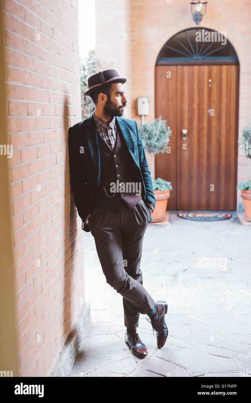 Young man leaning against brick wall Stock Photo - Alamy