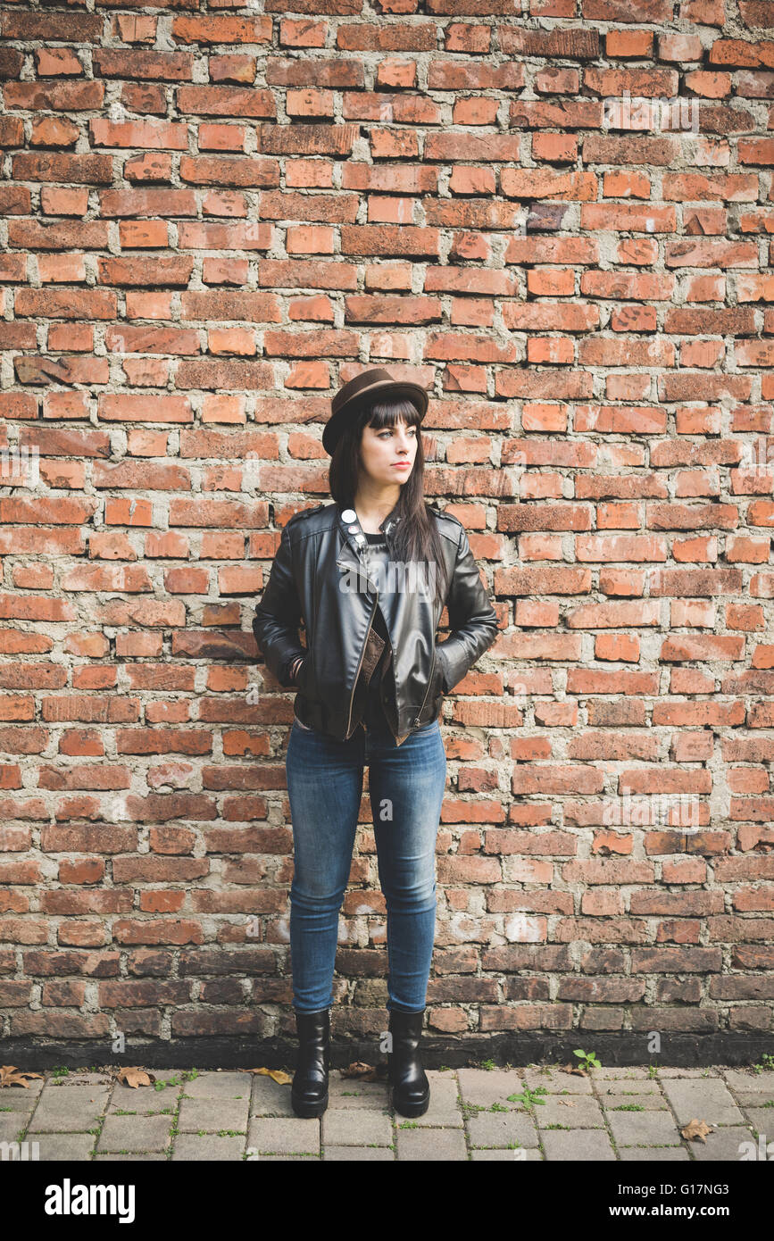 Young woman in front of brick wall Stock Photo - Alamy