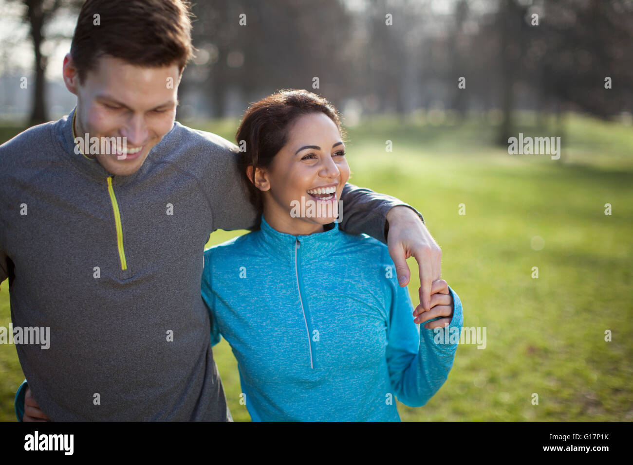 Young couple training, with arm around each other in park Stock Photo