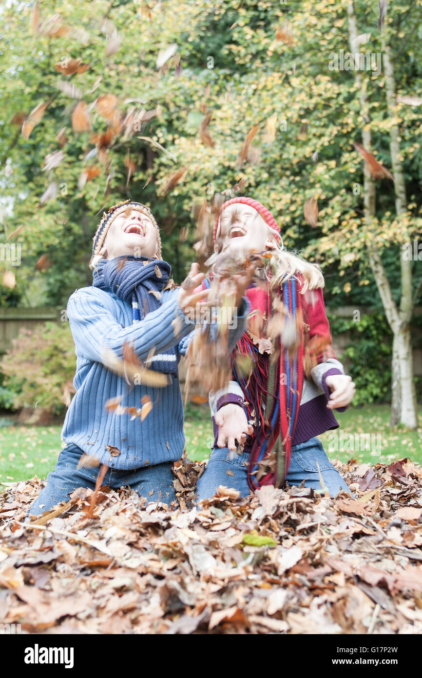 Brother and sister, throwing autumn leaves, laughing Stock Photo - Alamy
