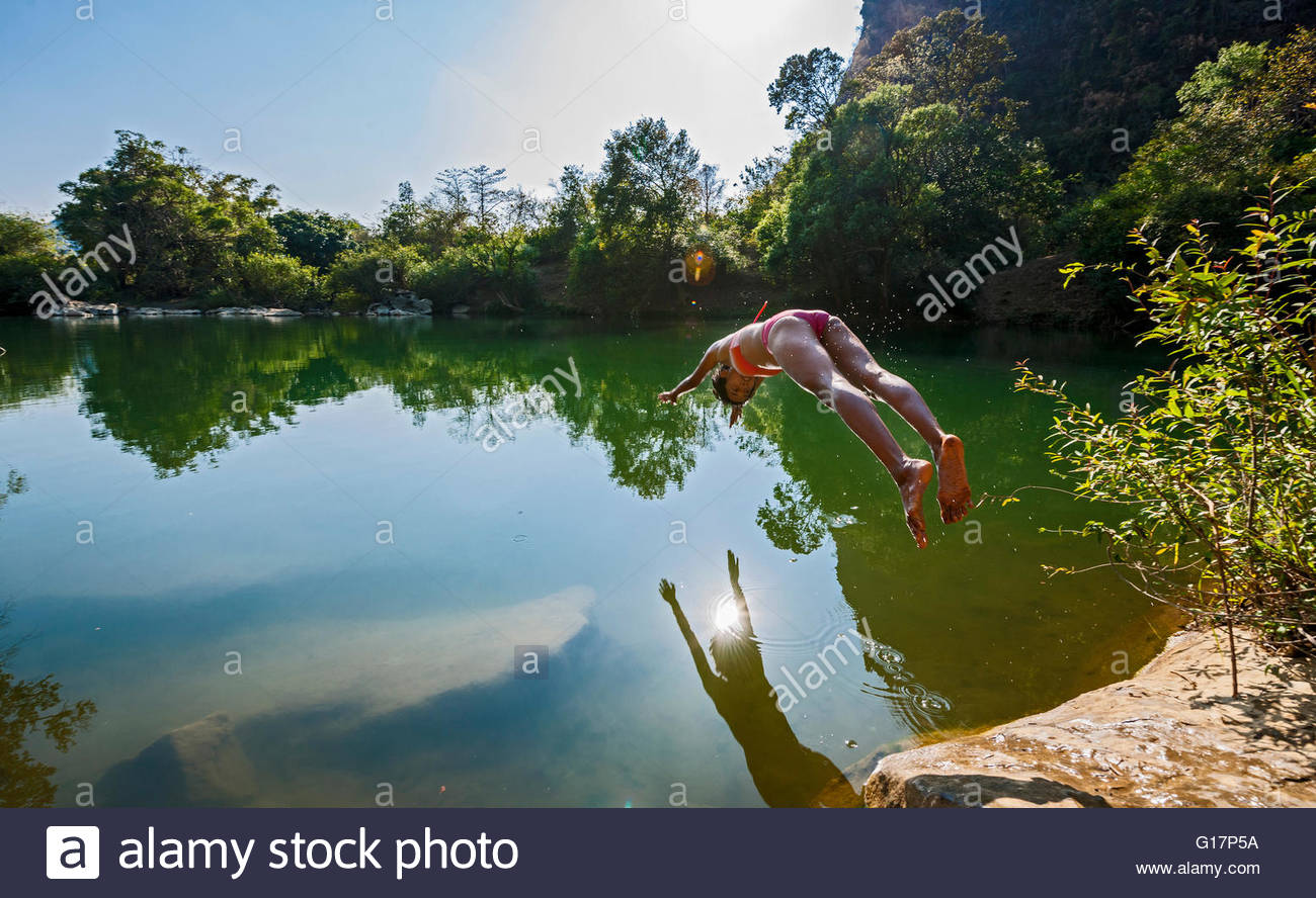 Young woman diving into Thafalang River, Thakhek, Khammouane, Laos ...