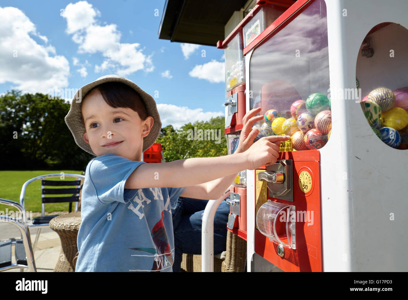 Happy boy pointing at gumball machine Stock Photo