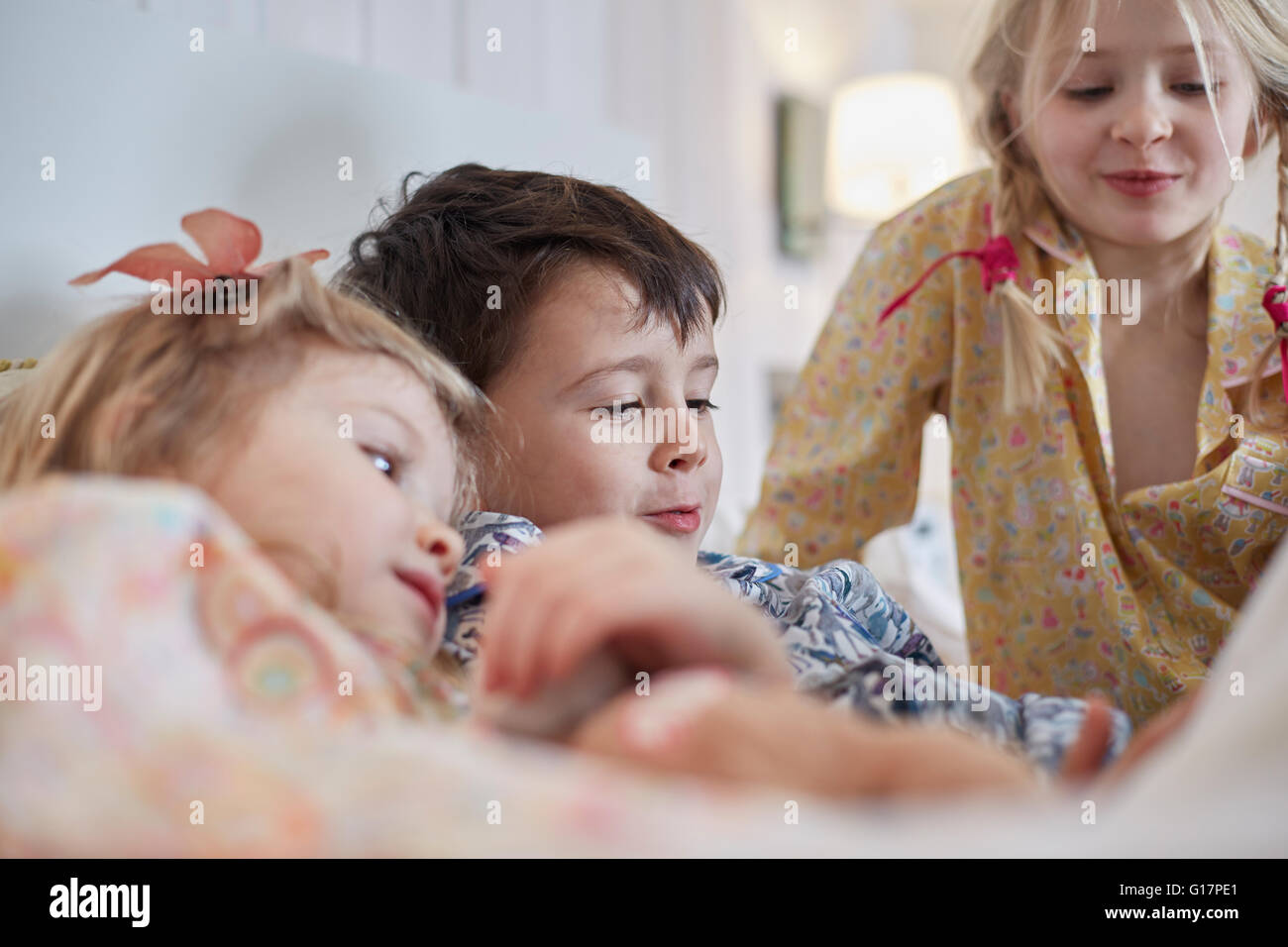 Children in pyjamas in bed Stock Photo