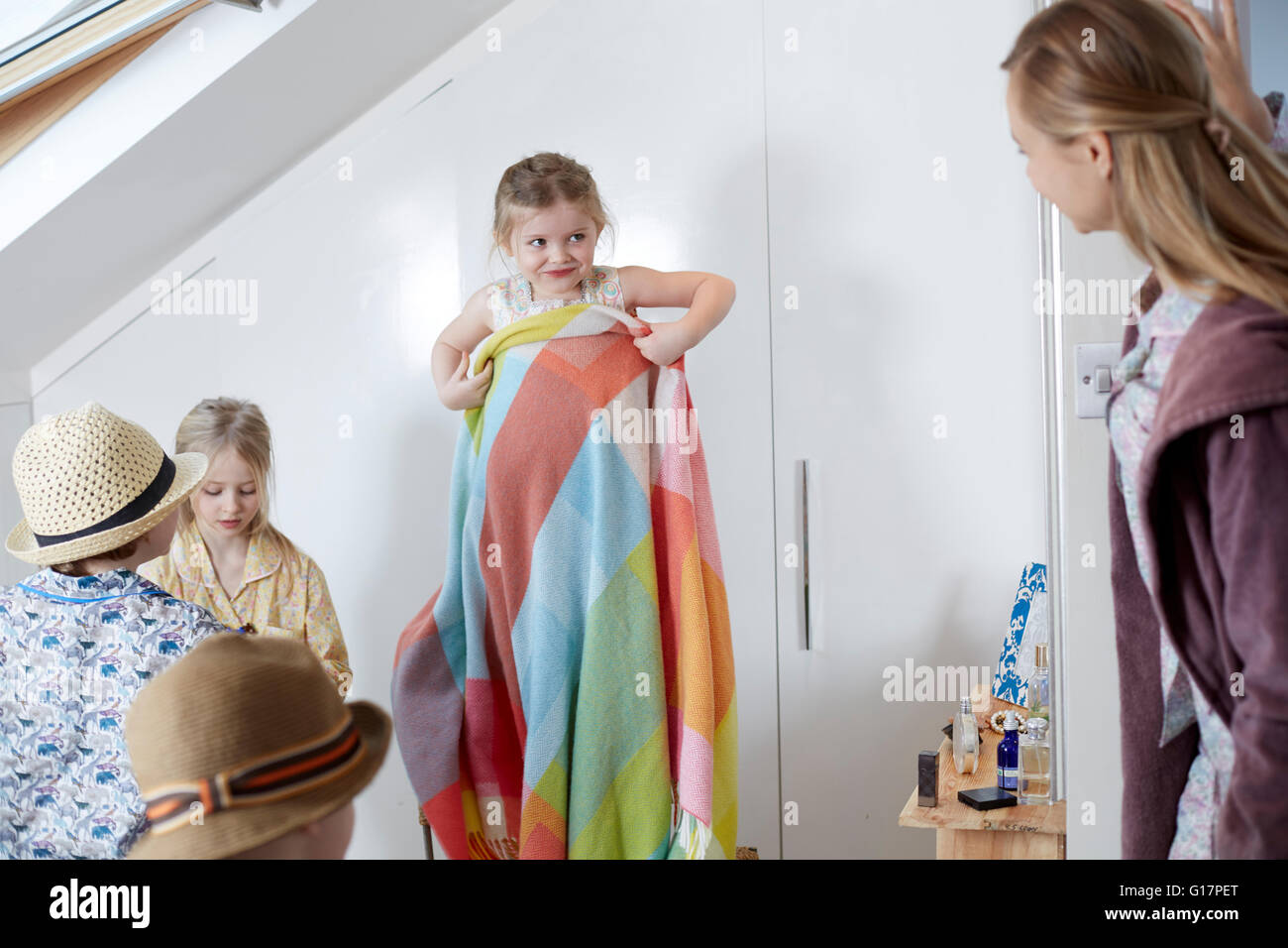 Mother and children playing dress-up in loft room Stock Photo