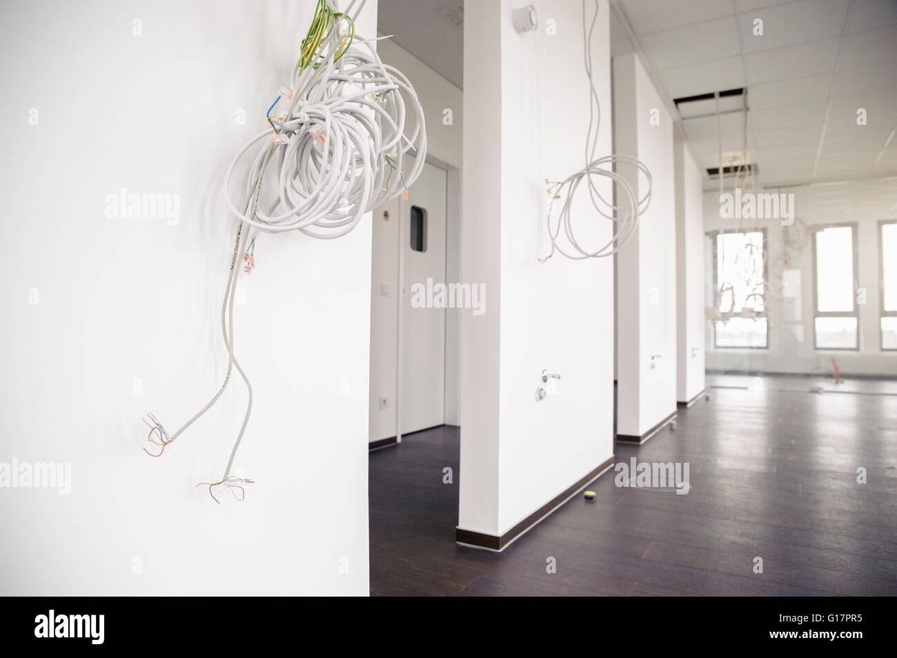 Network and power cables hanging from new office ceiling Stock Photo