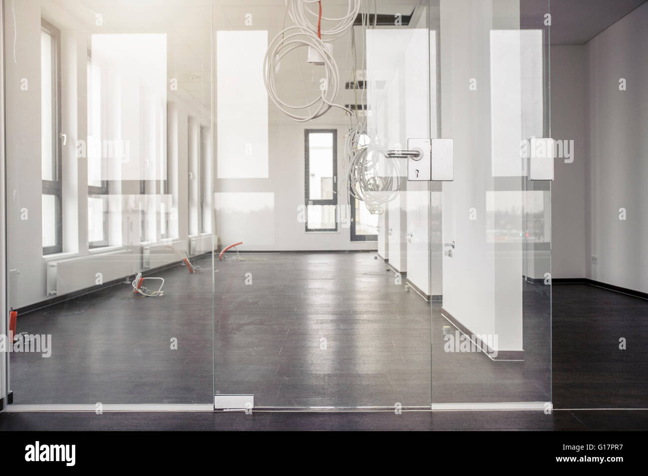 Glass Door In Front Of Power Cables Hanging From New Office