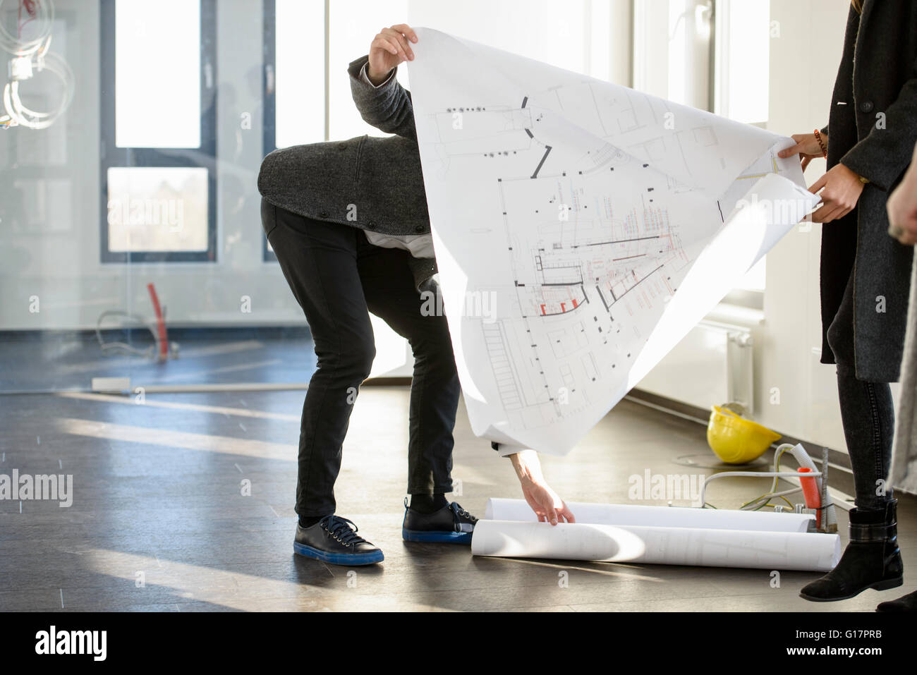 Architect picking up blue prints for clients in new office building Stock Photo
