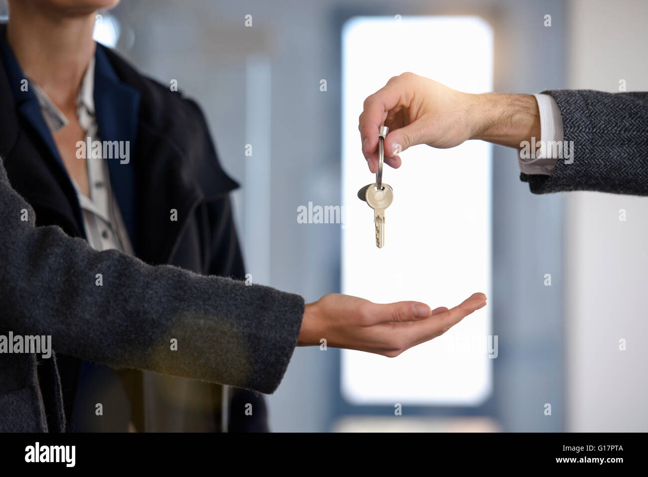 Cropped shot of man handing new office keys to businesswomen Stock Photo
