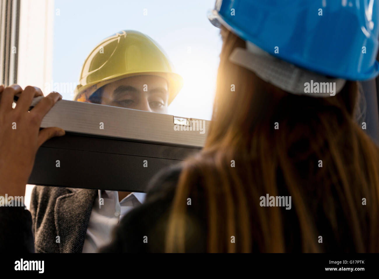 Architect and businesswoman wearing hard hats  inspecting new office window Stock Photo