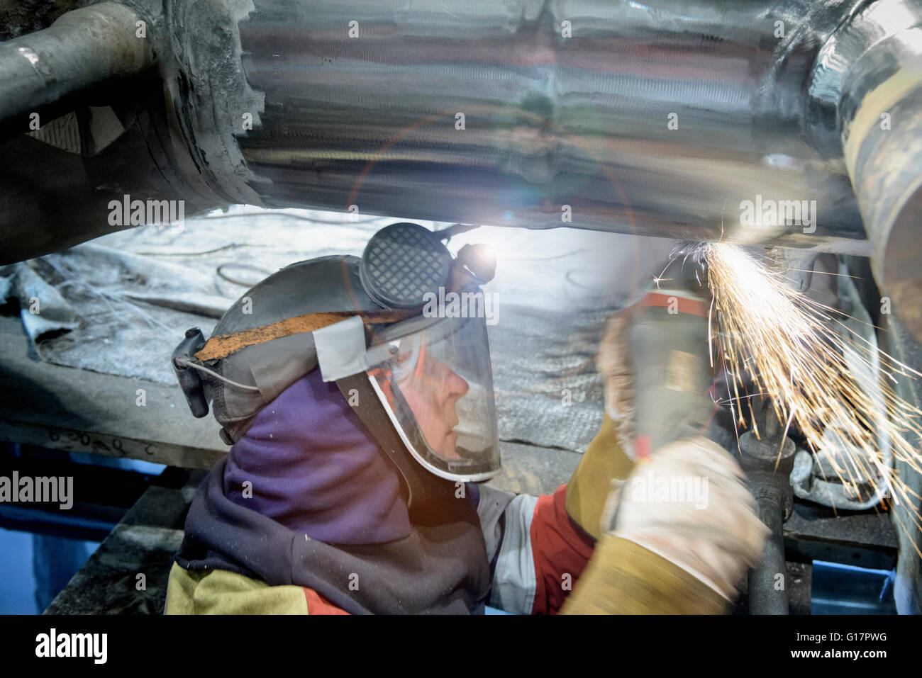 Worker grinding pipe in gas-fired power station Stock Photo