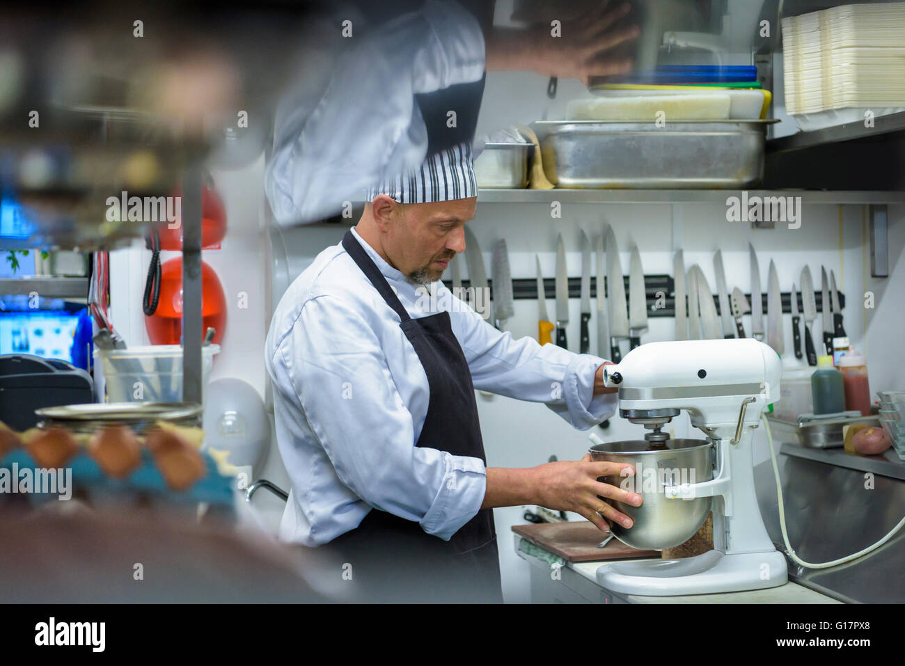Chef mixes food in traditional Italian restaurant kitchen Stock Photo