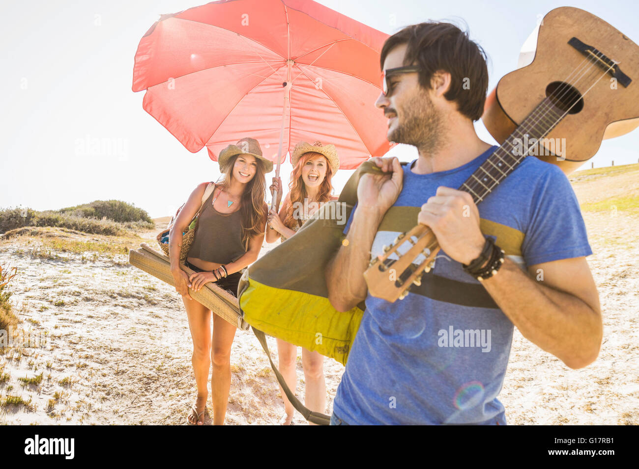 Mid adult women carrying beach umbrella at beach, Cape Town, South