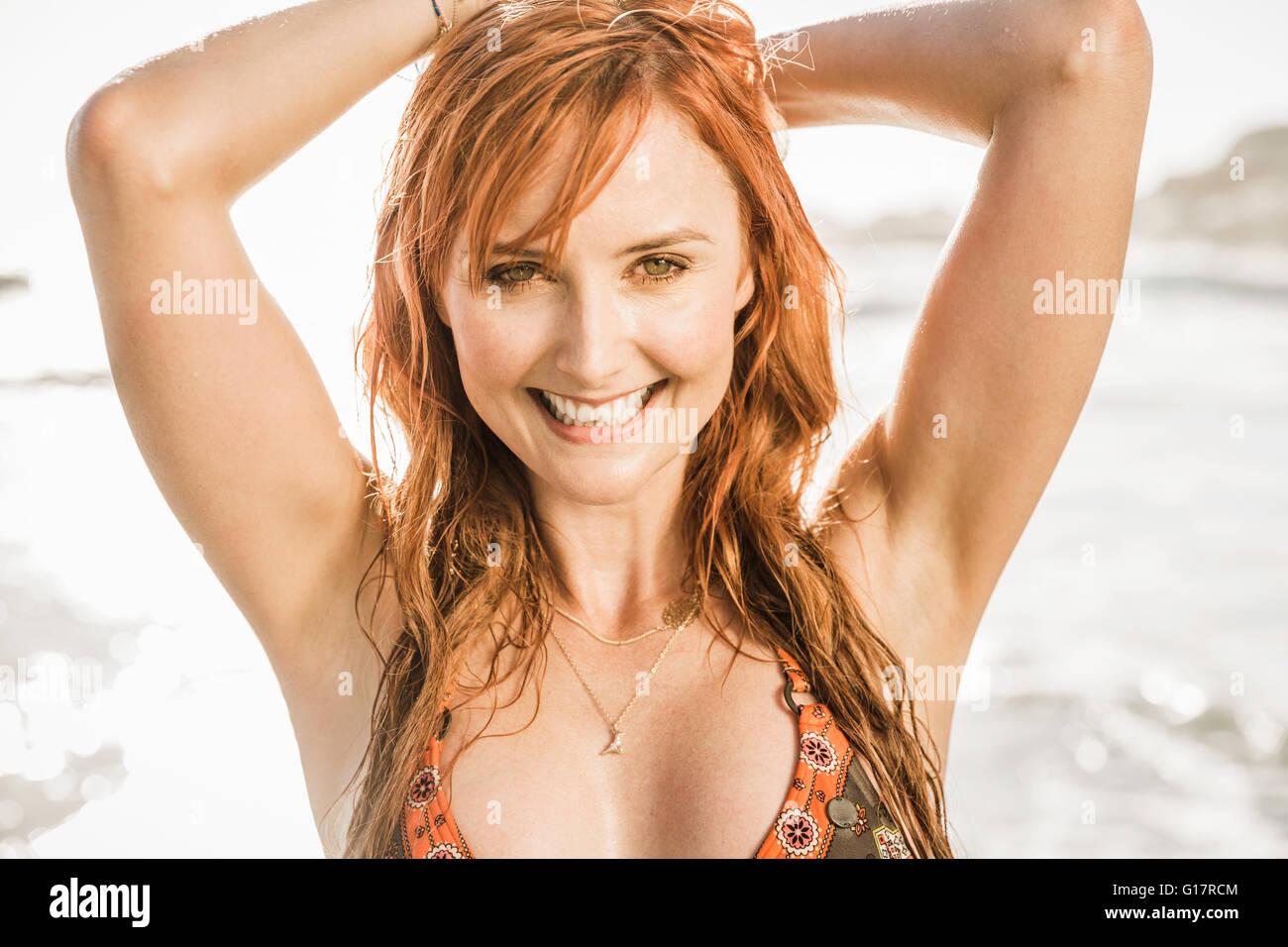 Portrait of woman with long red hair on beach, Cape Town, South Africa Stock Photo