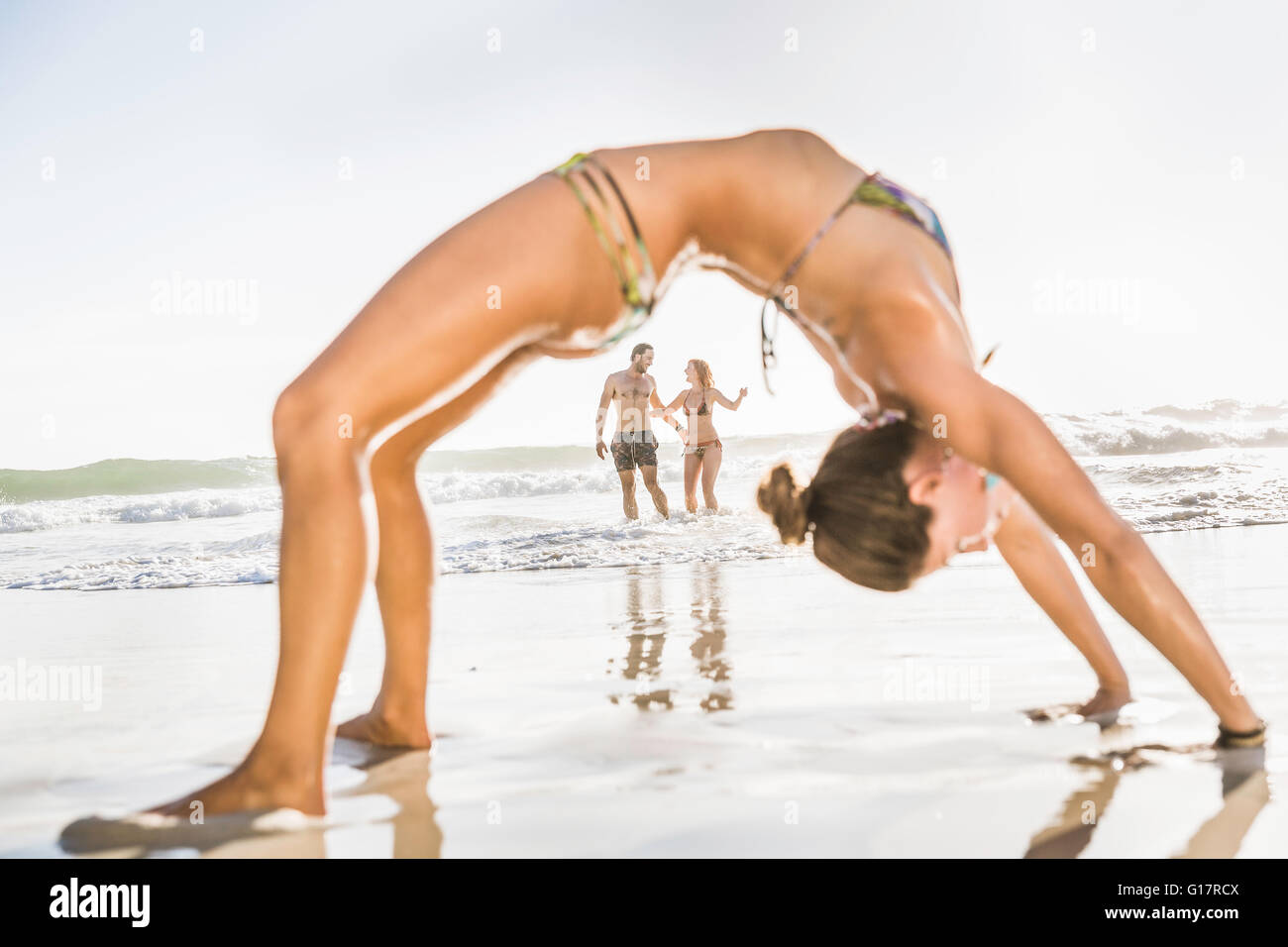 Mid adult woman wearing bikini bending over backwards on beach, Cape Town,  South Africa Stock Photo - Alamy