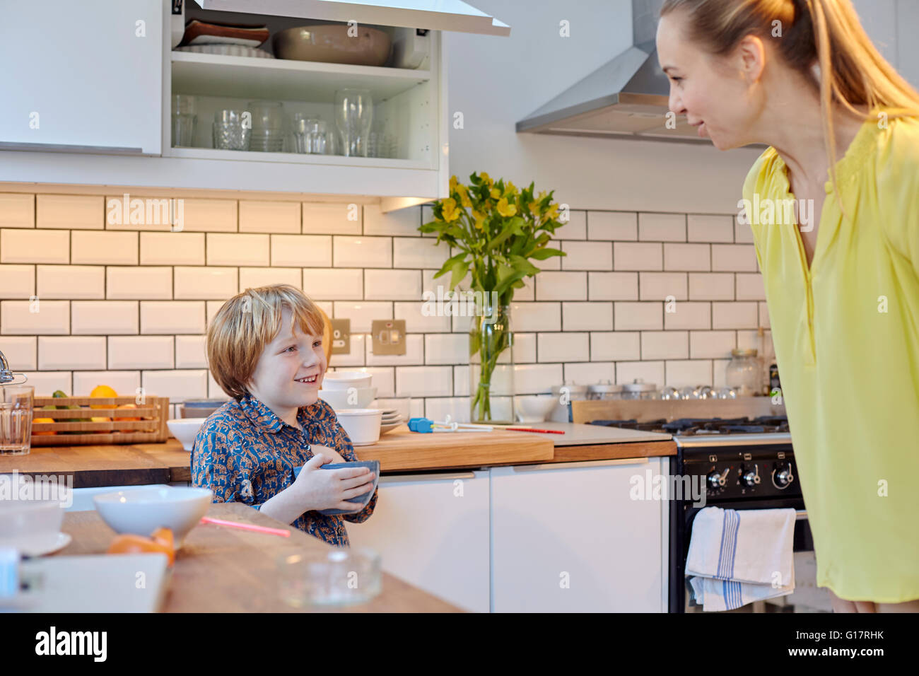 Mother speaking to son in kitchen Stock Photo